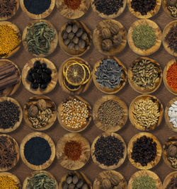 Top view of spices and food ingredients in wooden small plates .
