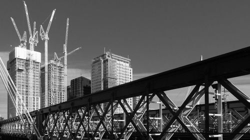 Modern bridge and buildings against sky at night