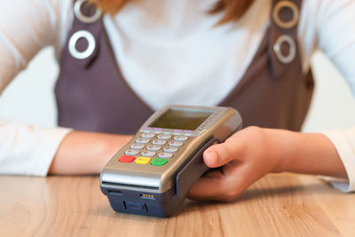 Close-up of woman using mobile phone on table