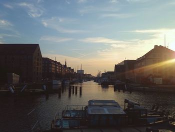 Boats in canal at sunset