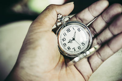 Close-up of hand holding pocket watch 