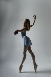 Ballet dancing against gray background