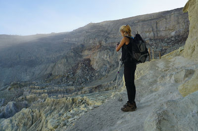 Rear view of woman standing on rock