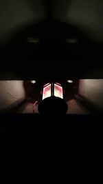 Close-up of hand on illuminated lamp at night