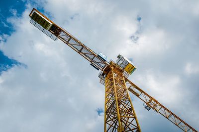 Low angle view of crane against sky