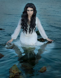 Portrait of young woman in water