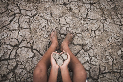 Close-up of farmer holding dry mud on field