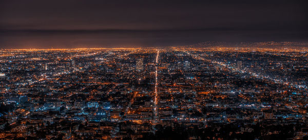 High angle view of illuminated city against sky at night