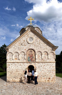 Rear view of women outside temple against building