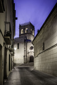 Alley amidst buildings in city at night