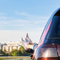 Feet outside the window, cityscape on background. woman driver put feet on car door, relaxing.