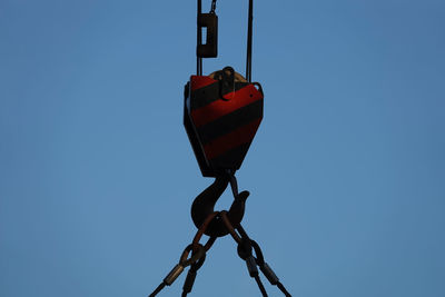 Low angle view of chain against clear blue sky