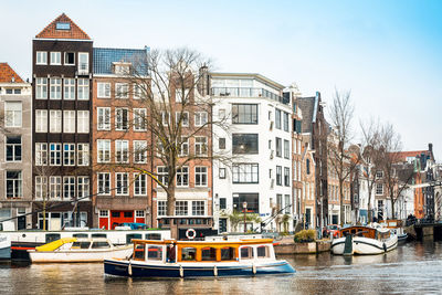 Boats in canal against residential buildings