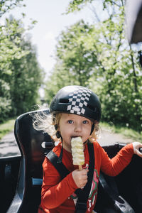 Girl wearing cycling helmet and eating ice-cream