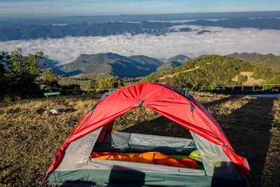 Tent on field by mountains against sky