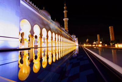 Illuminated sheikh zayed mosque against sky at night