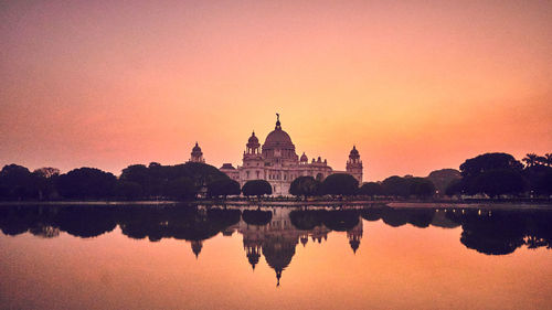 Reflection of historic building in lake during sunset