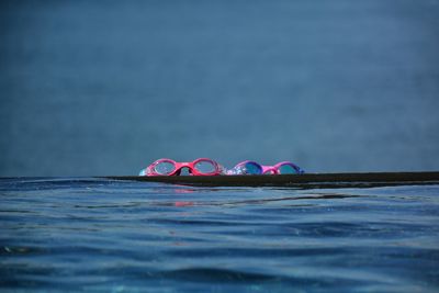 Close-up of swimming goggle's on edge of infinity pool