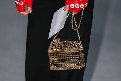 Midsection of woman holding gift box against black background