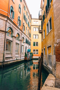 Canal amidst buildings in town against sky