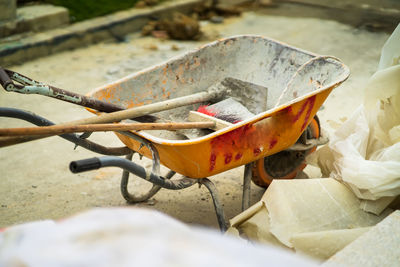 Yellow wheel barrow with various items at the construction site.