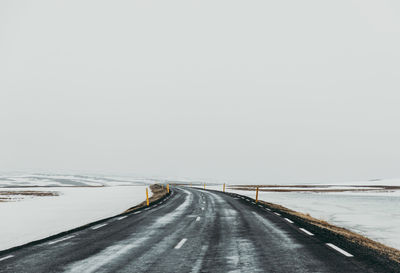 Empty road against clear sky during winter