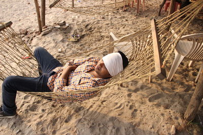Man sleeping on hammock at beach