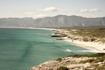 Scenic view of sea and mountains against sky