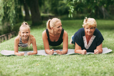 Multi generational family exercising plank on grass