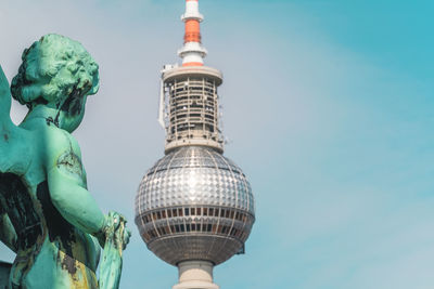 Low angle view of angel statue against fernsehturm