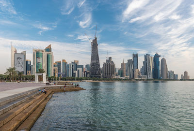 Modern buildings in city against cloudy sky