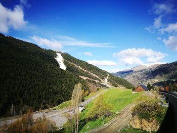 Scenic view of road by mountains against sky