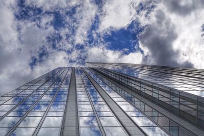 Low angle view of building with reflection of clouds