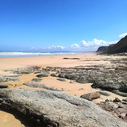 Scenic view of beach against blue sky