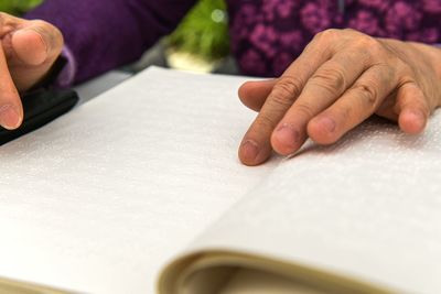 Hands of a blind person reading braille