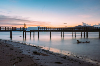 Pier over sea against sky during sunset