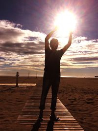 Man standing on beach against sky during sunset