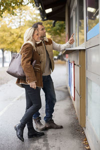 Young couple ordering food from store on street