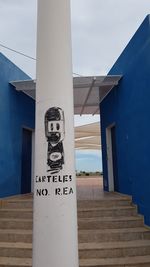 Text on wall against blue sky