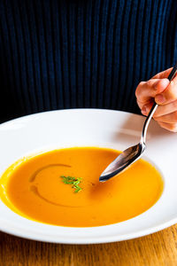 Close-up of hand holding bowl of soup