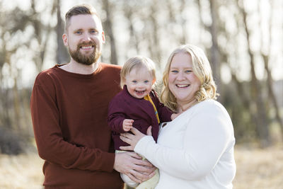 Portrait of smiling mother carrying daughter