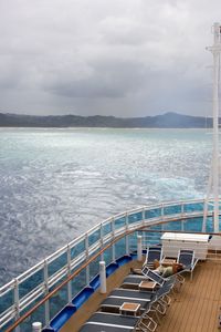 High angle view of boat sailing on sea against cloudy sky