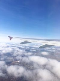 Aerial view of airplane wing against blue sky