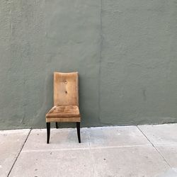 Empty chair against wall