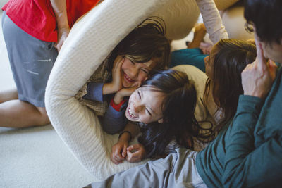 A happy laughing family playing and wrestling together at home