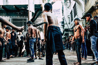 Rear view of people walking on street in city