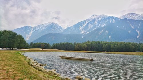 Scenic view of lake by mountains against sky