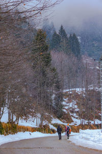 People walking on snow field during winter