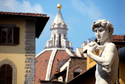 Low angle view of statue against buildings