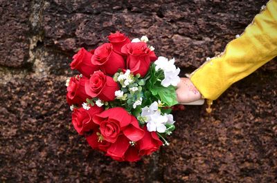 Close-up of hand holding rose bouquet
